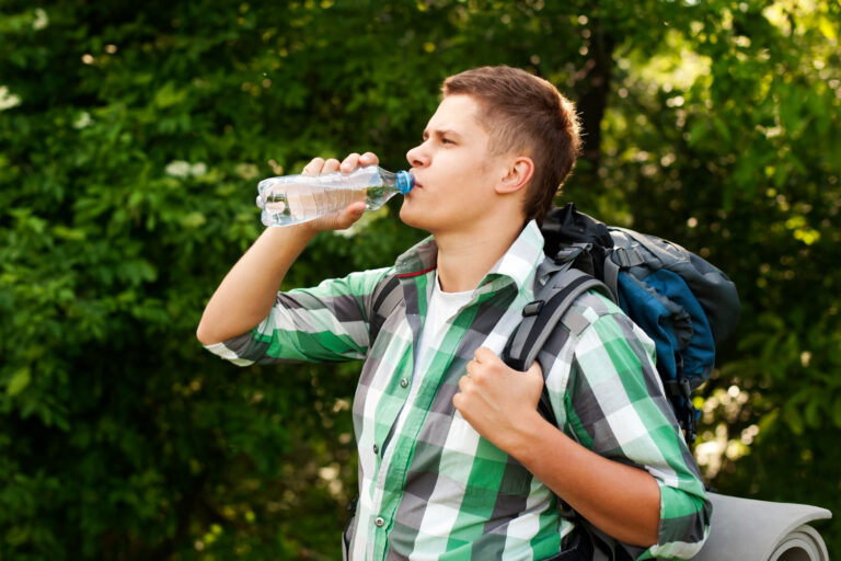 man drinking from plastic water bottle